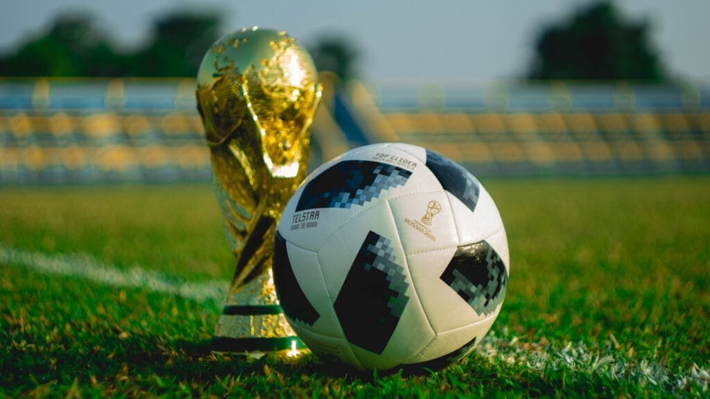 كرة قدم بجانب كأس على ملعب كرة قدم