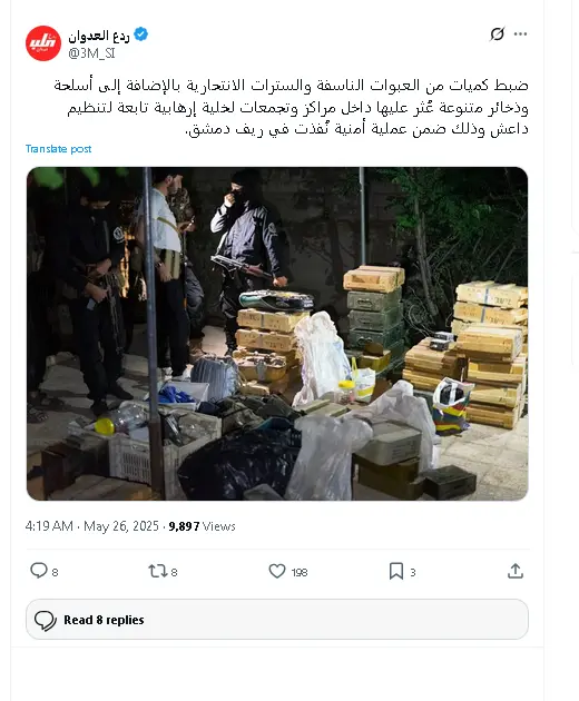 صورة تُظهر مجموعة من الأشخاص يرتدون ملابس عسكرية وهم يقفون بجانب صناديق خشبية تحتوي على أسلحة وذخائر، مع أكياس بلاستيكية بيضاء مكدسة على الأرض. الصورة تُظهر نتائج عملية أمنية نفذتها وزارة الداخلية السورية في ريف دمشق (الغوطة الغربية) يوم 26 مايو 2025، حيث تم ضبط أسلحة ومواد متفجرة بحوزة خلايا تابعة لتنظيم الدولة.