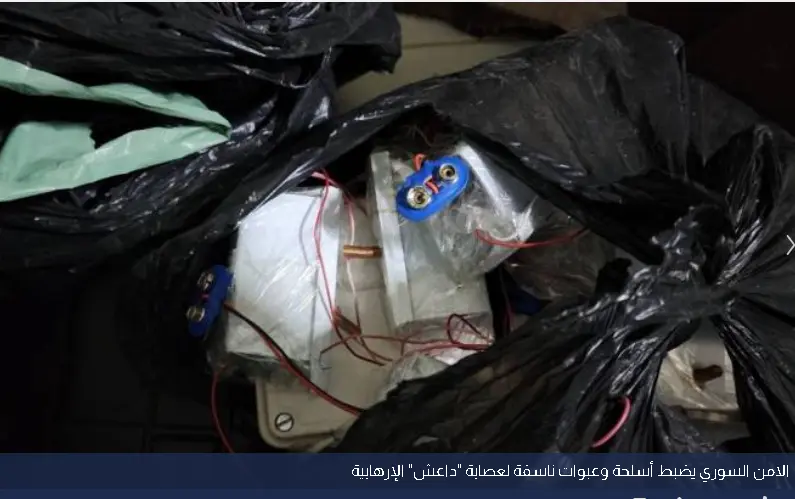 صورة تُظهر أكياس بلاستيكية سوداء تحتوي على مواد متفجرة وأجهزة إلكترونية مع أسلاك متصلة، بما في ذلك بطاريات ومفجرات. الصورة تُظهر جزءًا من المضبوطات خلال عملية أمنية نفذتها وزارة الداخلية السورية في الغوطة الغربية قرب دمشق لتفكيك خلايا تابعة لتنظيم الدولة.